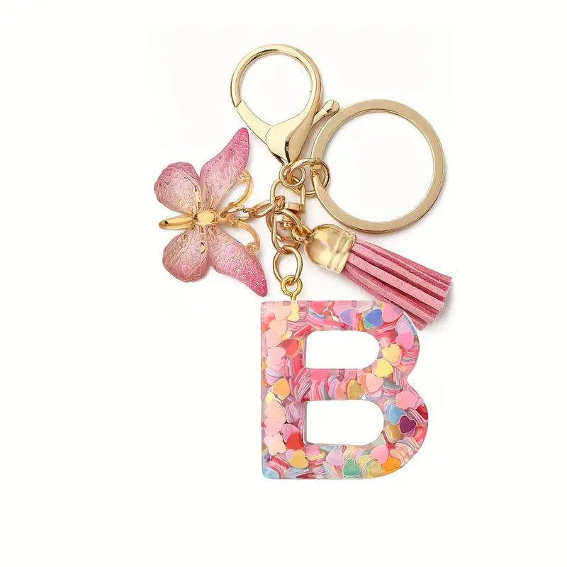 Porte-clés femme lettre initiale colorée – Breloque papillon et pompon rose tendance