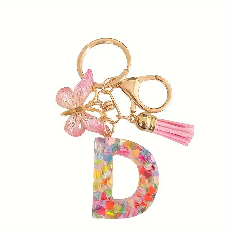 Porte-clés femme lettre initiale colorée – Breloque papillon et pompon rose tendance