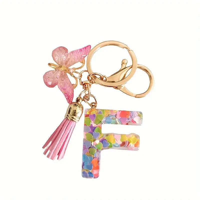 Porte-clés femme lettre initiale colorée – Breloque papillon et pompon rose tendance