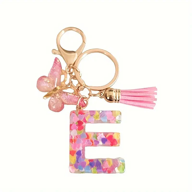 Porte-clés femme lettre initiale colorée – Breloque papillon et pompon rose tendance