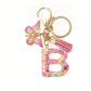 Porte-clés femme lettre initiale colorée – Breloque papillon et pompon rose tendance
