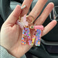 Porte-clés femme lettre initiale colorée – Breloque papillon et pompon rose tendance