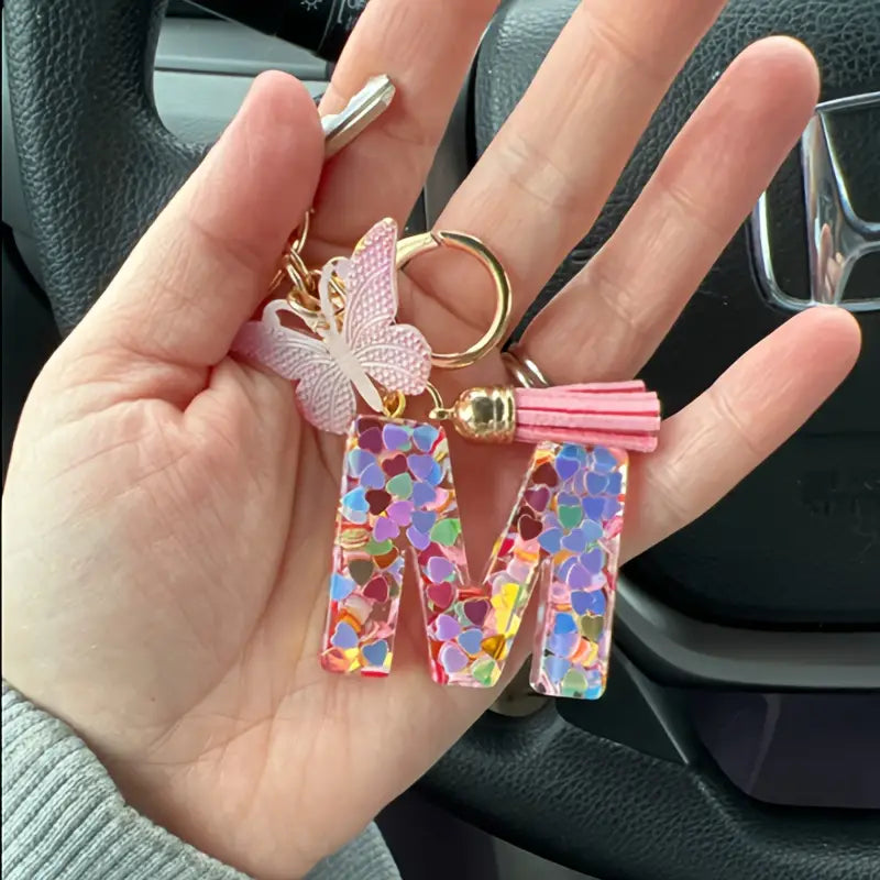 Porte-clés femme lettre initiale colorée – Breloque papillon et pompon rose tendance